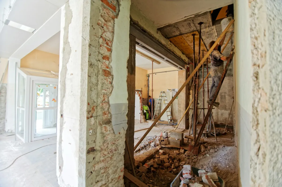 Öppen vägg under renovering med framdragen elkabel och verktyg
