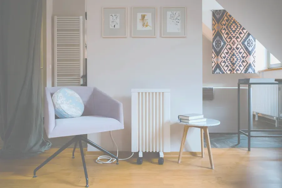 Elradiator på hjul i ett vardagsrum med handdukstork i bakgrunden